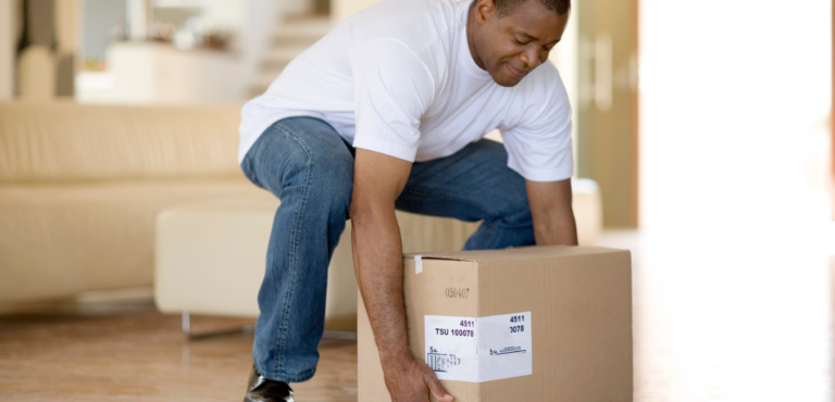 Persona adulta levantando una caja durante una actividad cotidiana.