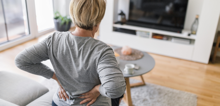 Persona con dolor lumbar durante una actividad física cotidiana.