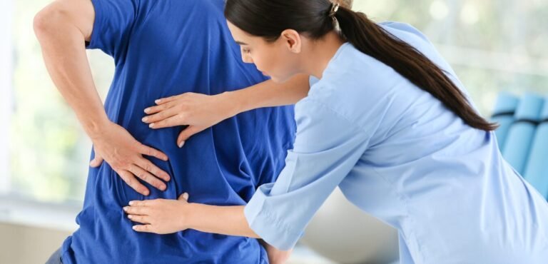 Fisioterapeuta realizando una valoración a una persona con dolor lumbar.